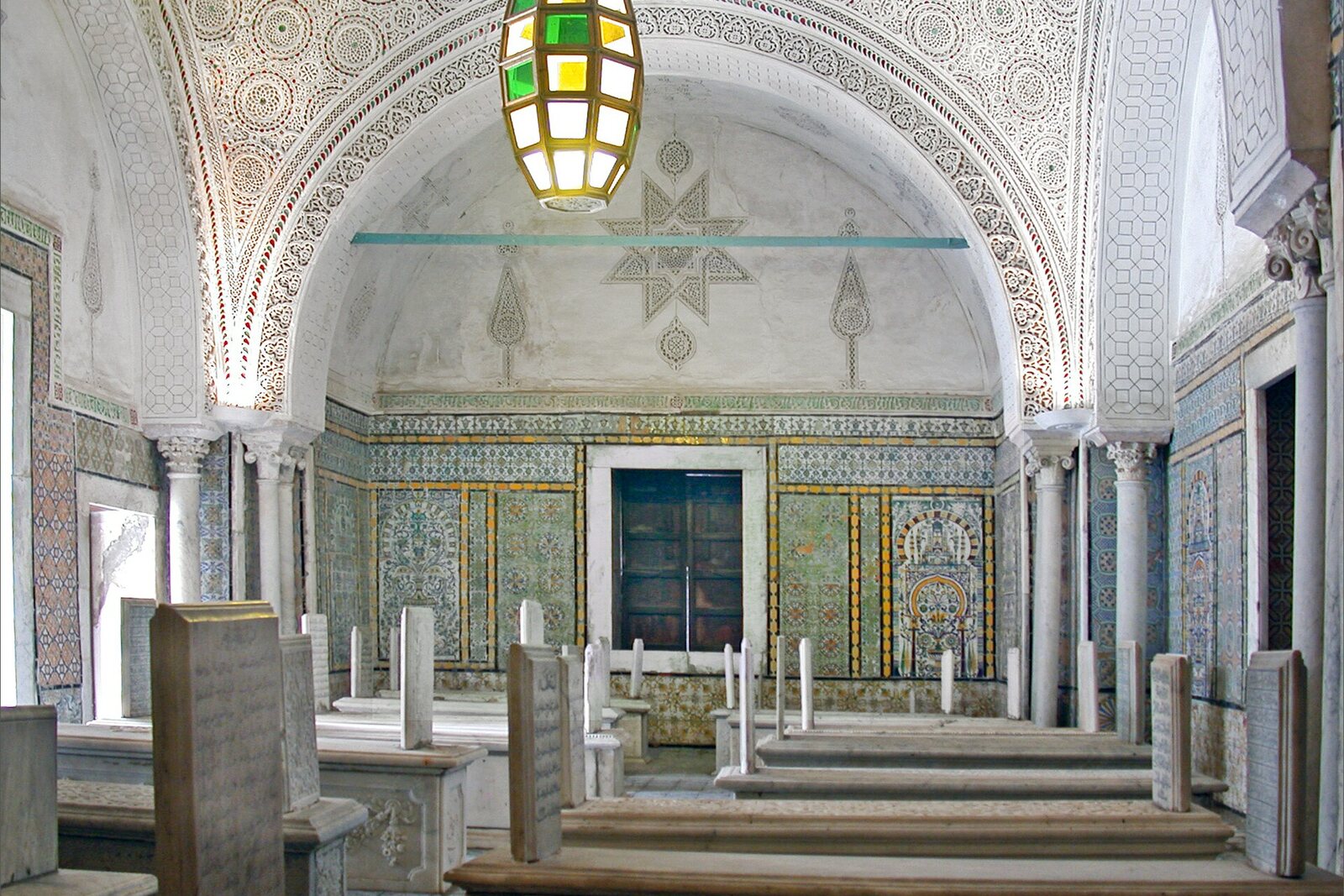 The burial hall of Tourbet el Bey with marble slabs and a painted vault.