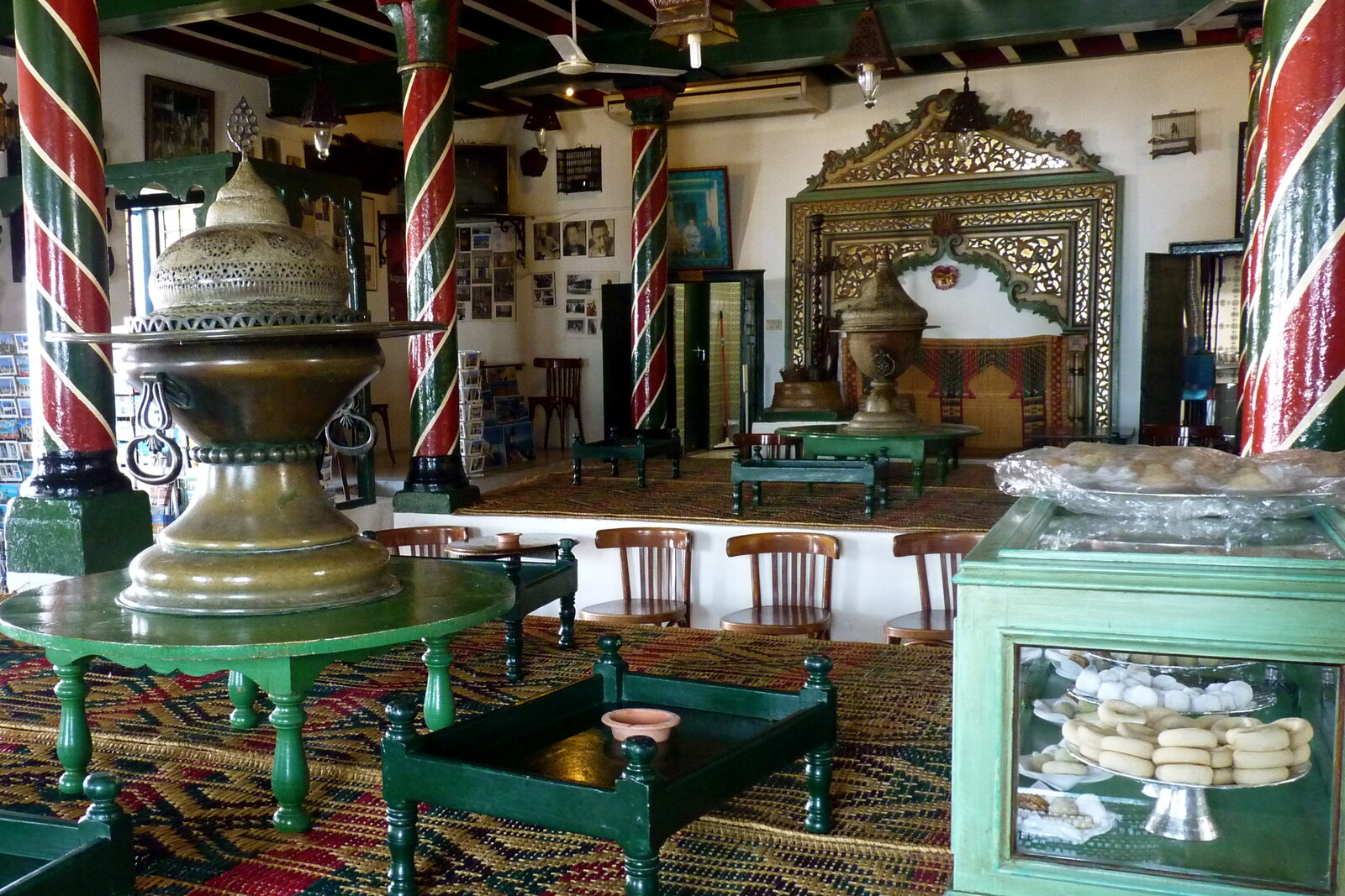 Interior of Café des Nattes with visitors and columns.