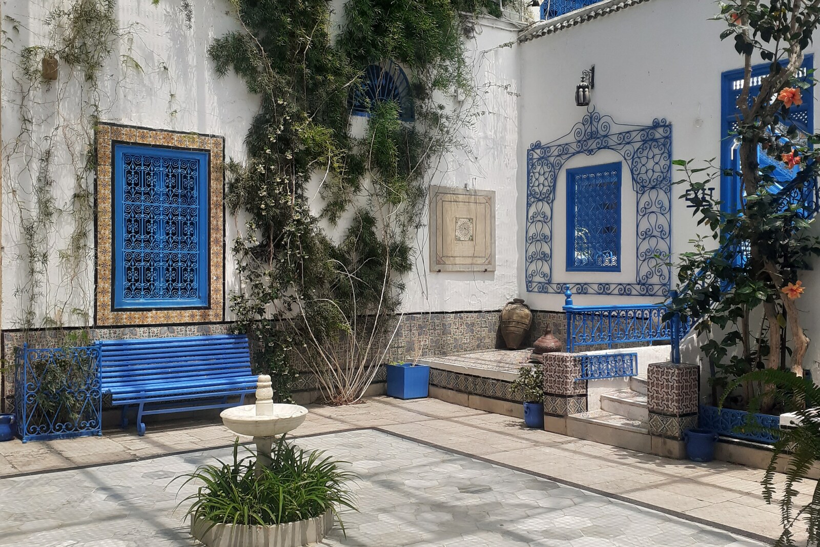 The facade of Dar El Annabi, with white walls and blue doors.