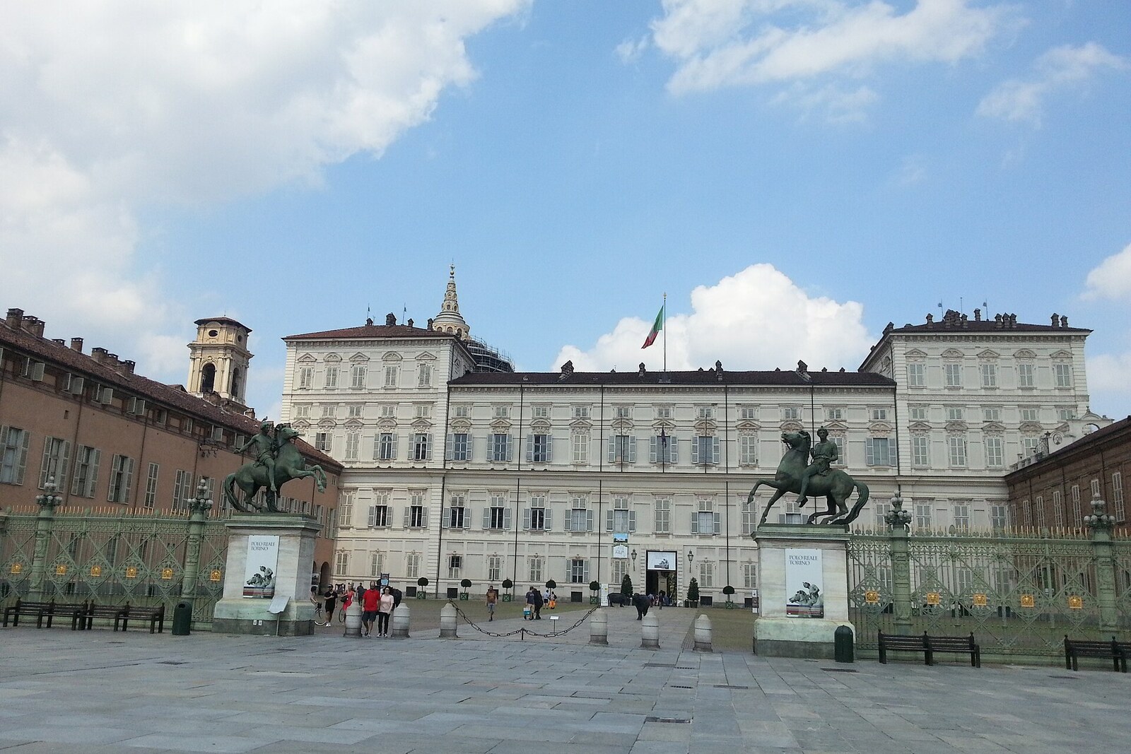 The austere facade of the Royal Palace of Turin behind the palace railing.