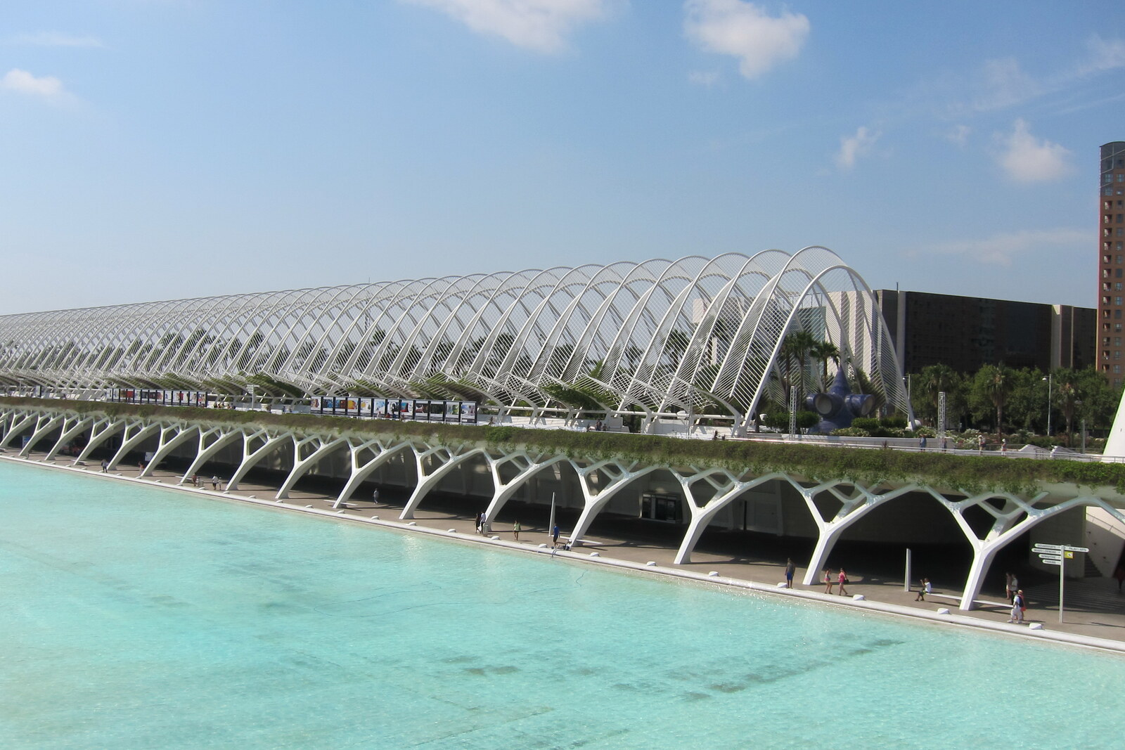 White arches of the Umbracle above palms and sculptures