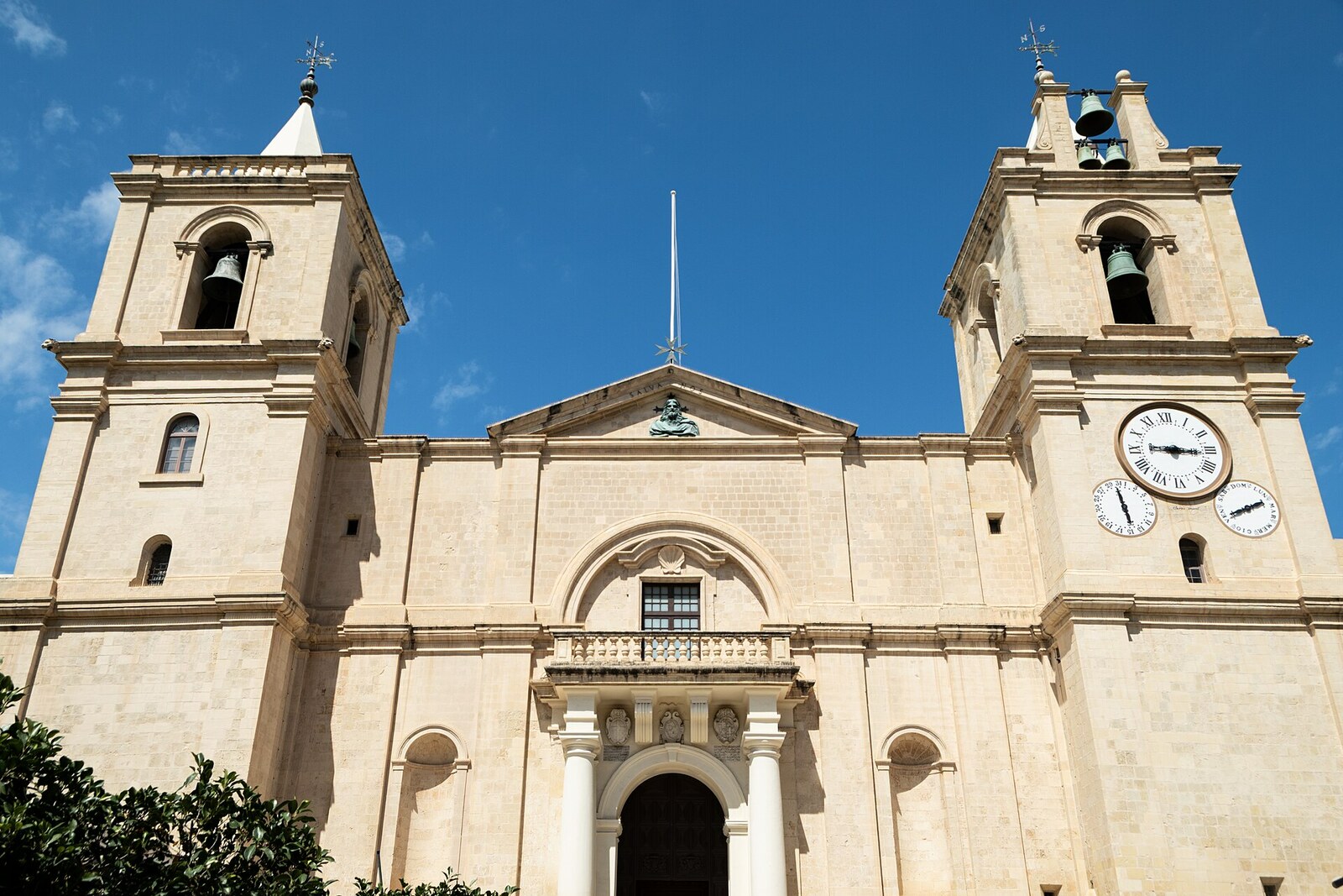 The restrained stone facade of St John's Co-Cathedral with two towers.