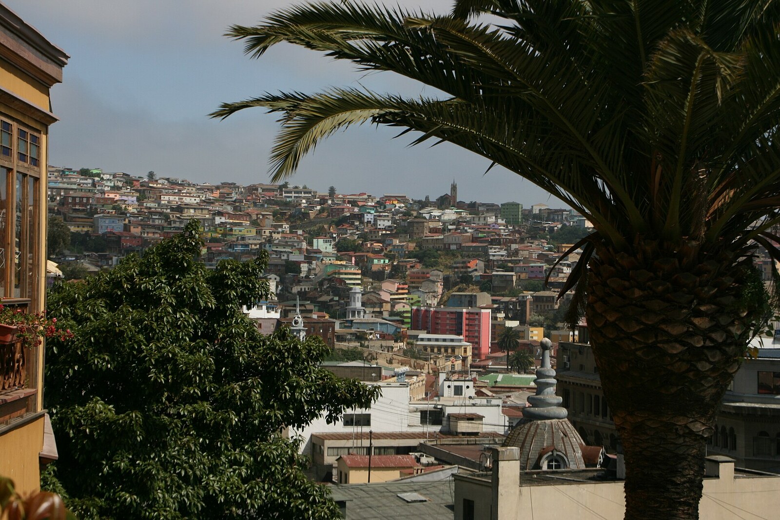 View from Paseo Gervasoni over roofs, hills, and part of a tower below.
