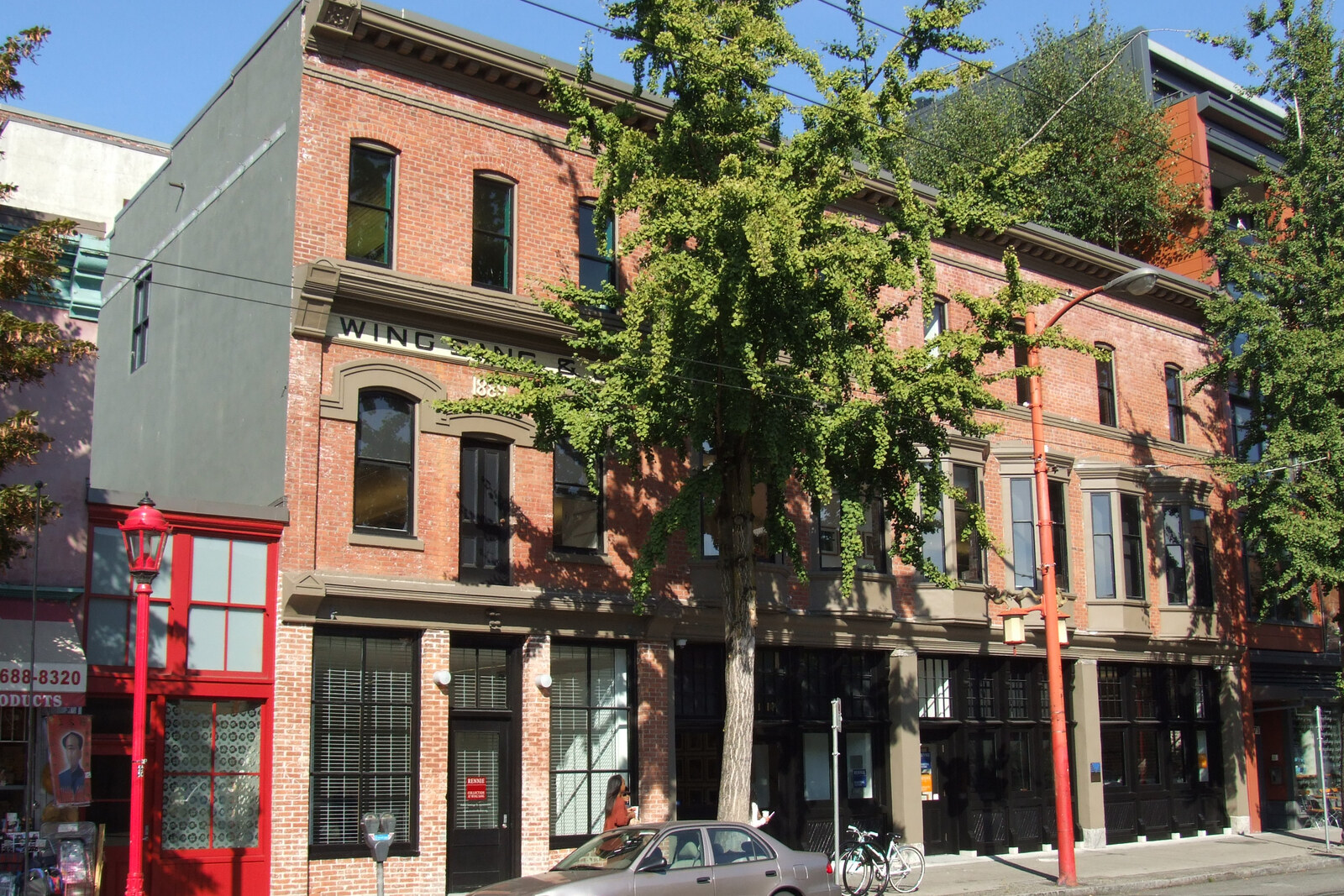 Old brick Wing Sang Building with an arched entrance and the inscription 1889