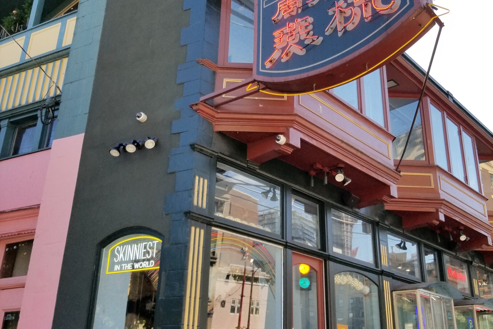 Narrow corner Sam Kee Building with balconies and a Jack Chow Insurance sign