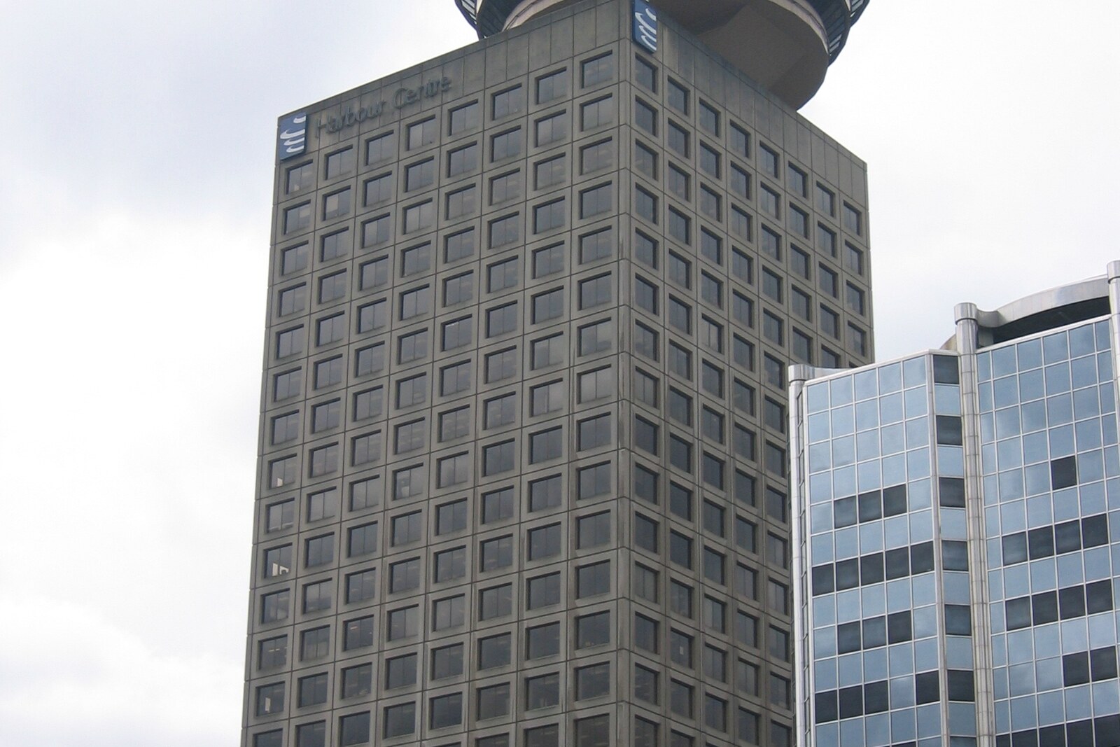 The Harbour Centre tower with a circular observation deck, rising above a Vancouver street.