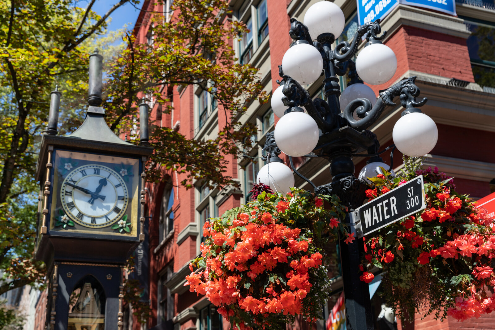 The Gastown Steam Clock on Water Street in Gastown, with brick buildings around it.