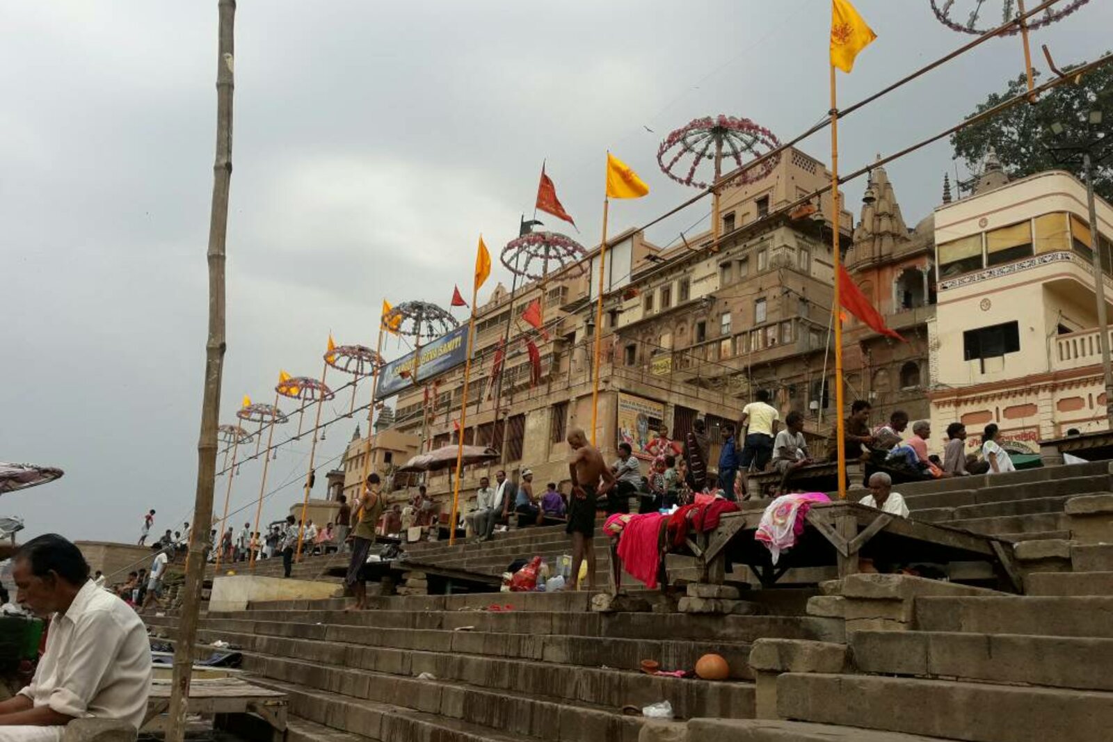 Dashashwamedh Ghat with steps, umbrellas, and people by the water.