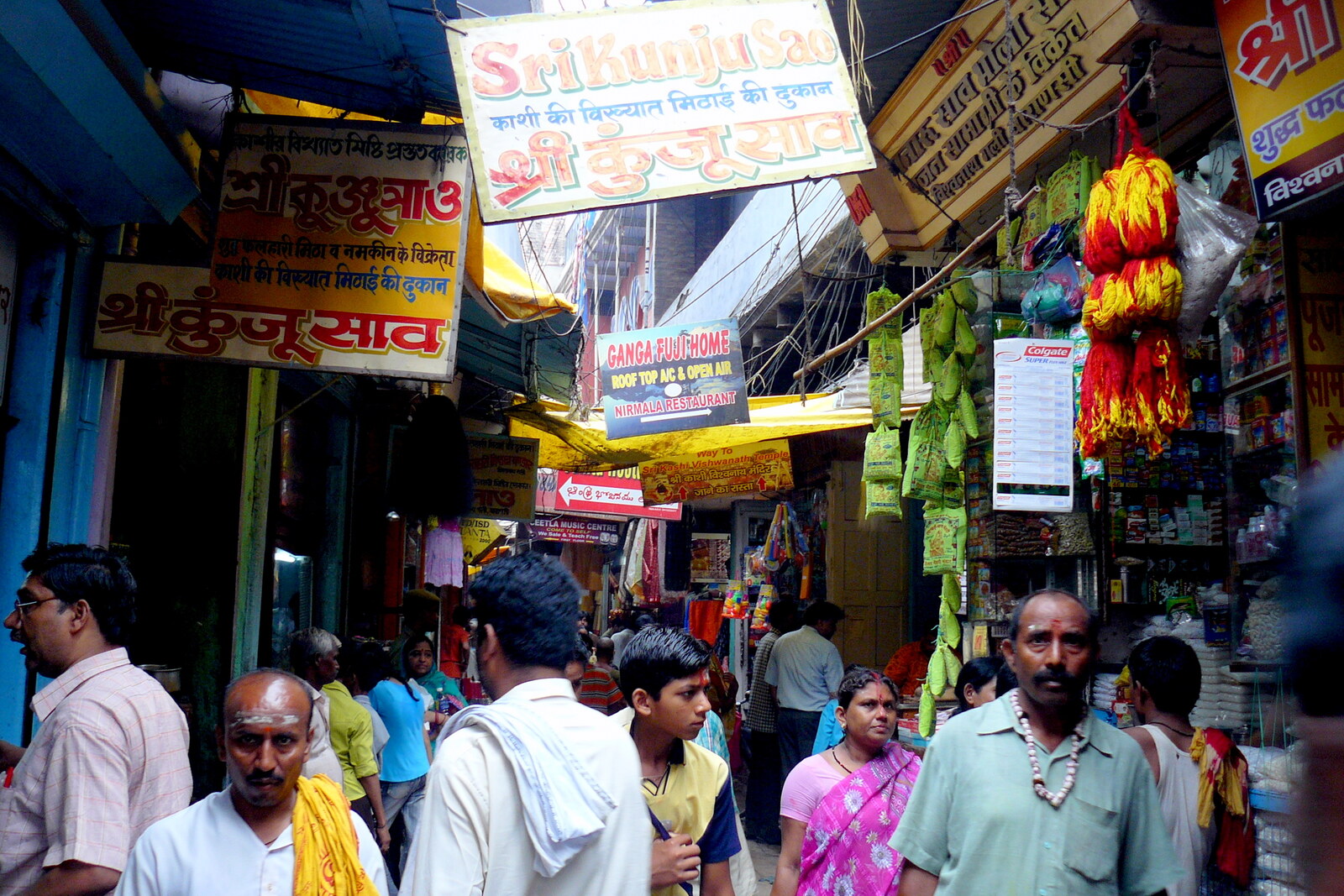 Calle estrecha con tiendas y una multitud de personas en Varanasi