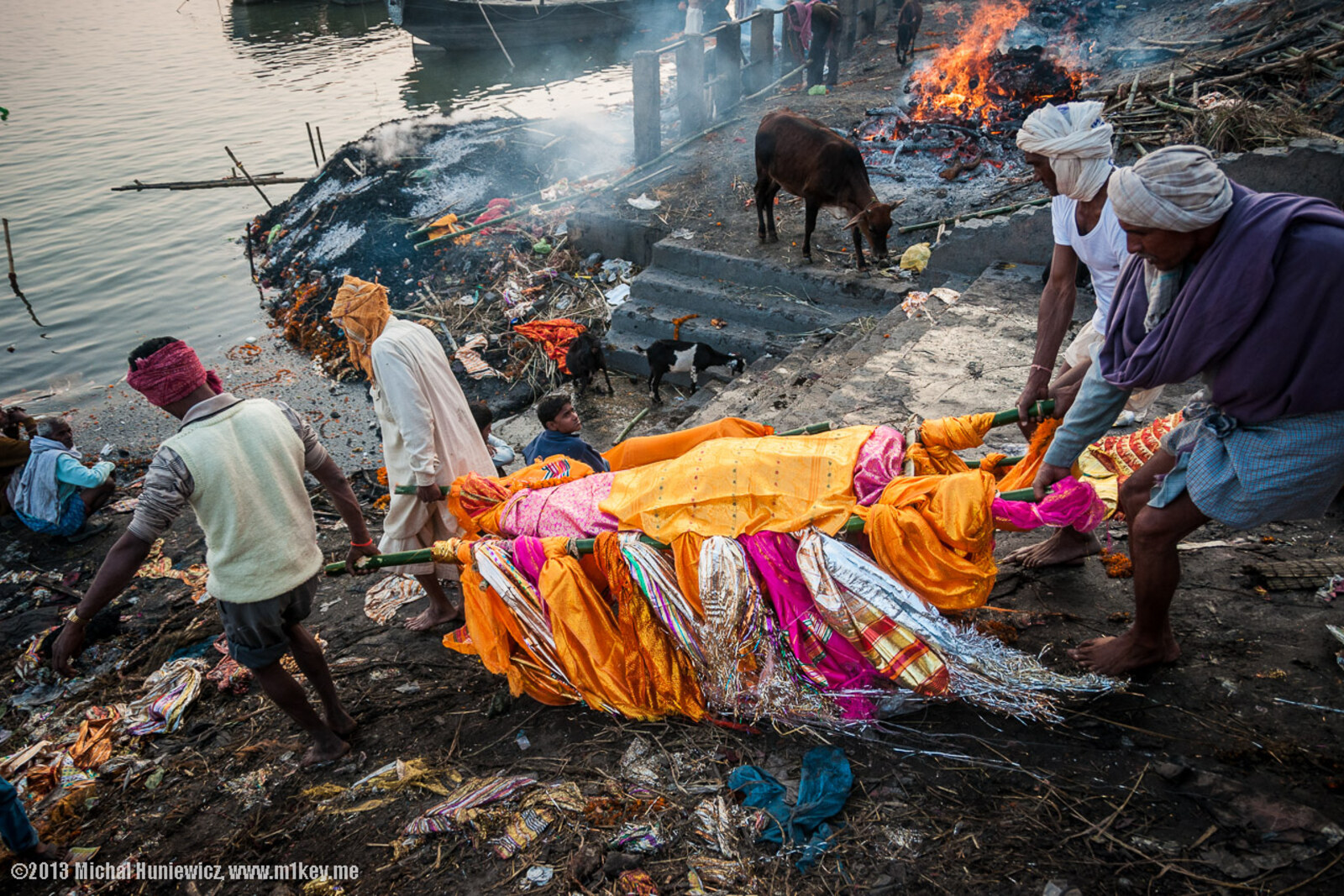 Manikarnika Ghat con piras humeantes y barcas en el río Ganges