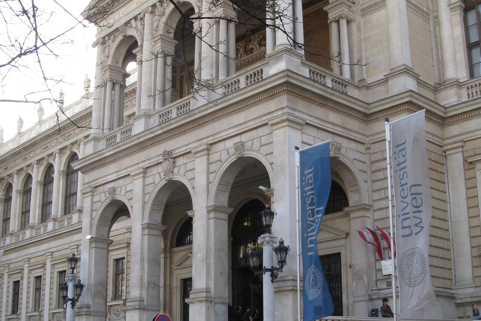 The main facade of the University of Vienna with a colonnade and a statue of Athena in the center
