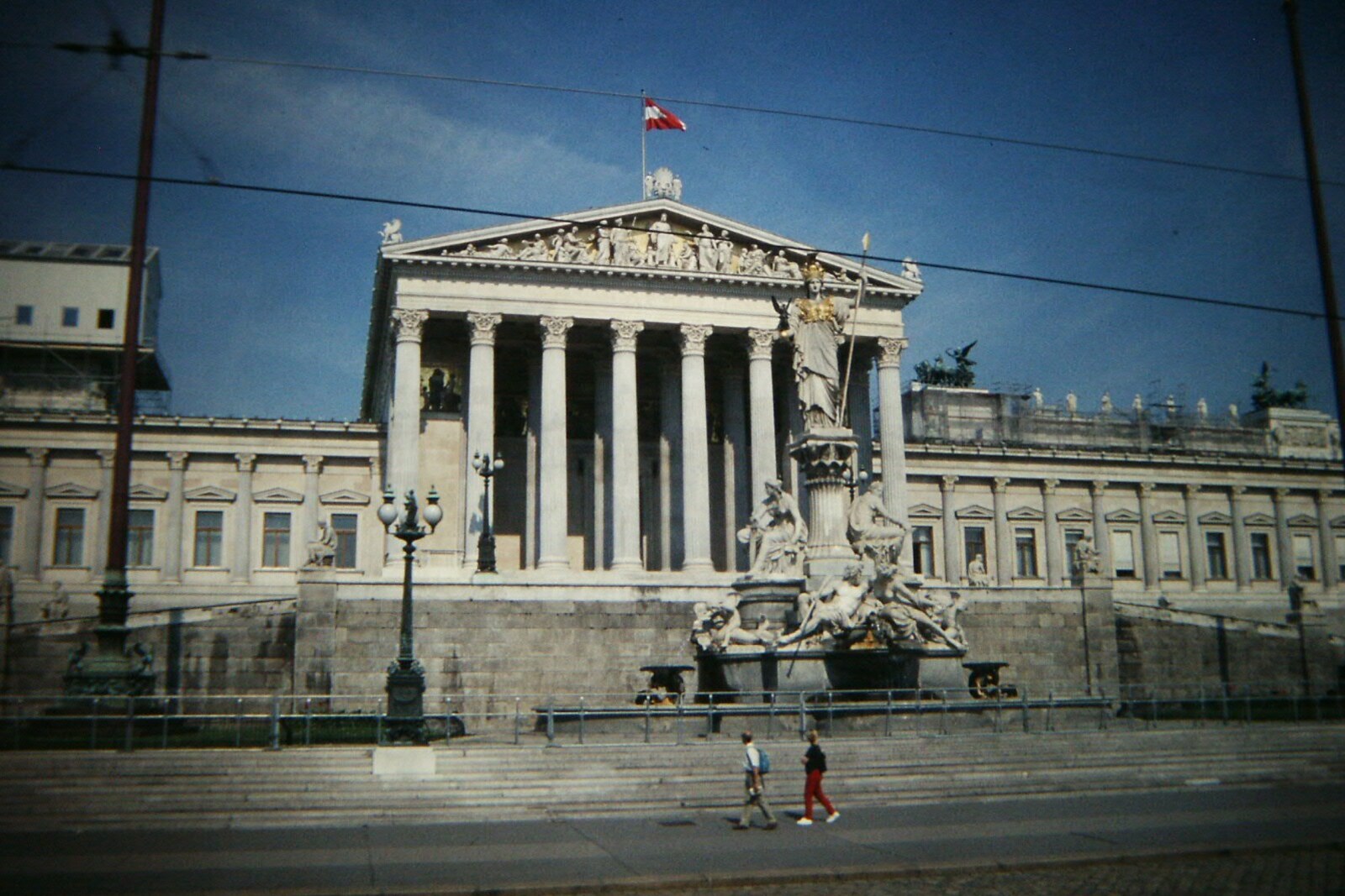 The Neo-Renaissance facade of Parliament with columns and a statue of Athena