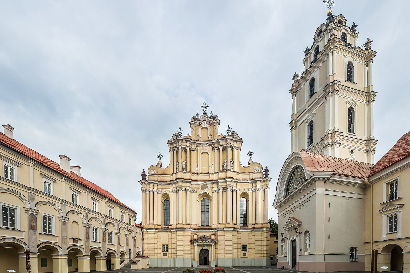 The Grand Courtyard of Vilnius University with arcades, a Baroque church, and a bell tower.