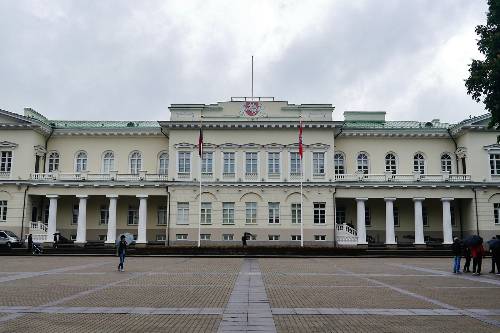 The main façade of the Presidential Palace with long colonnades and a flag.