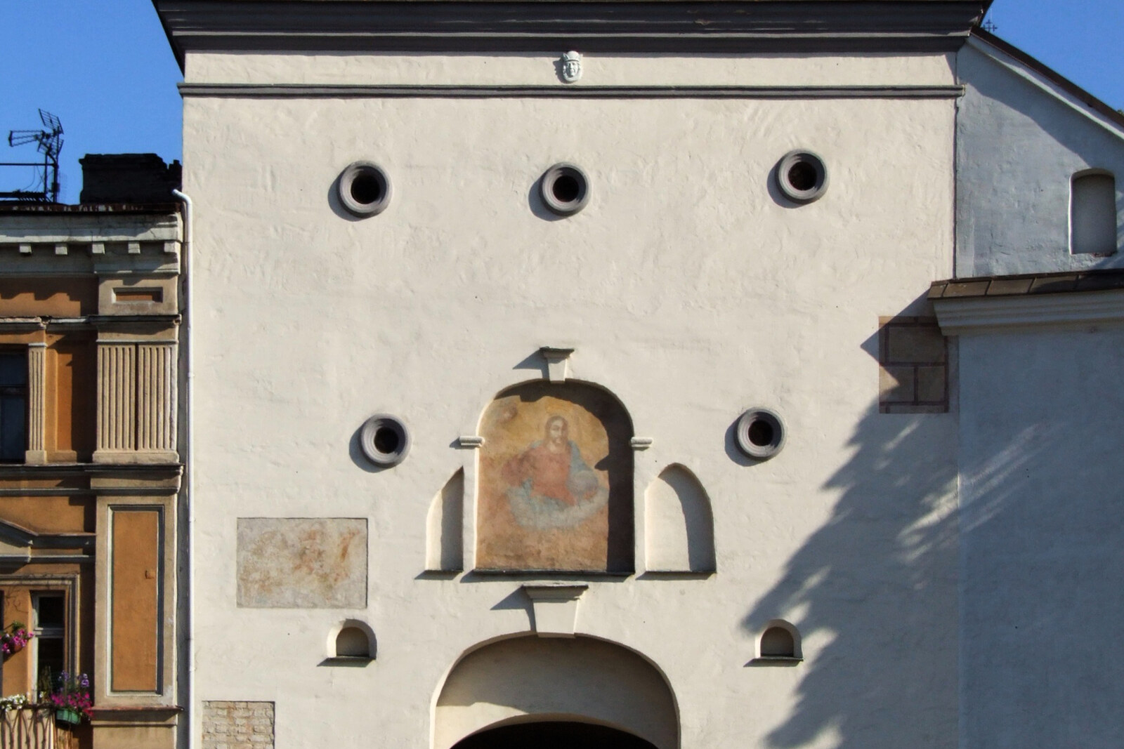 The outer facade of the Gate of Dawn, with round gunports and an arch.