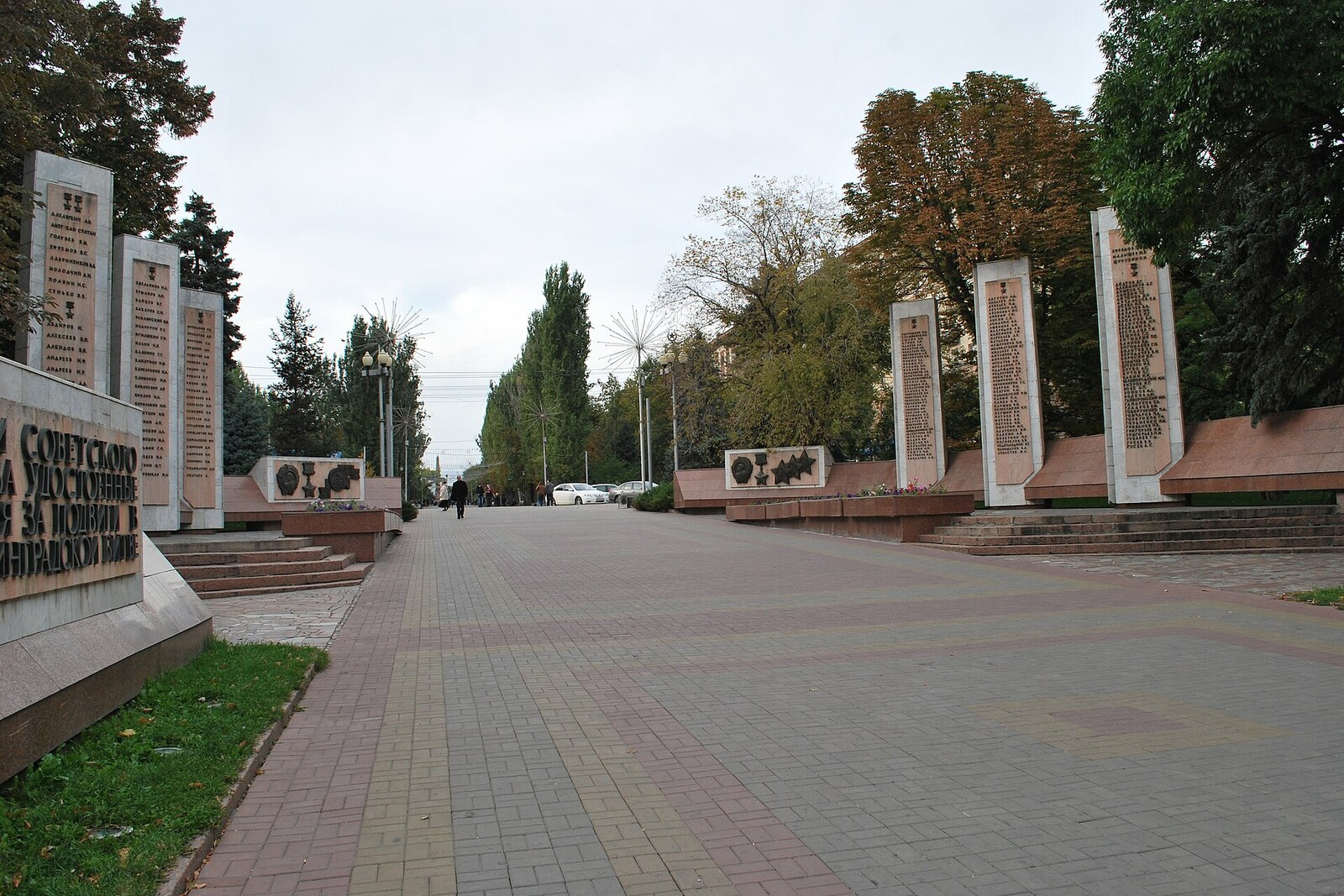 The pedestrian Alley of Heroes with trees and stelae.