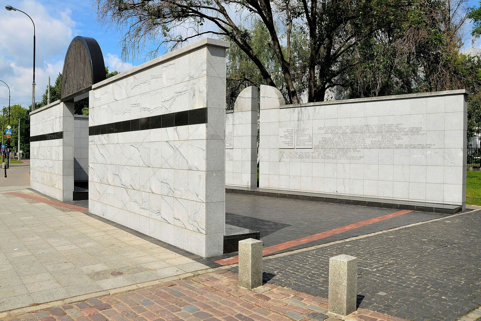 The white marble passage of the Umschlagplatz memorial with a vertical black stripe.