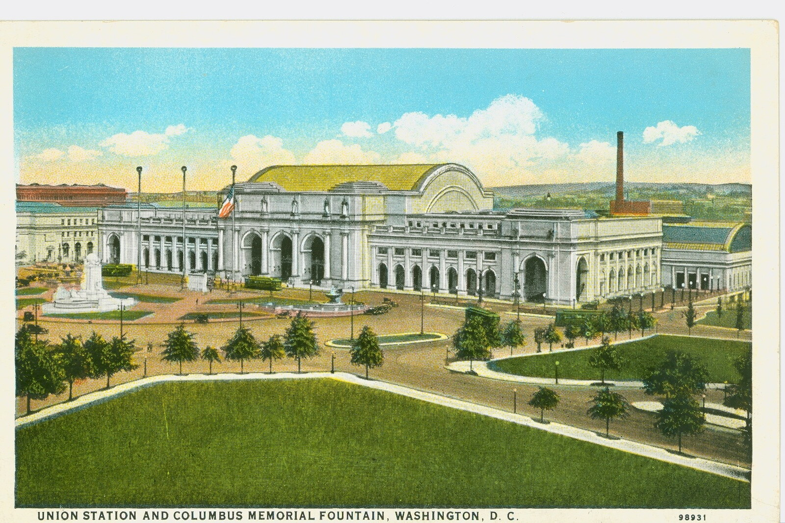 The white façade of Union Station with arches and statues under a blue sky.