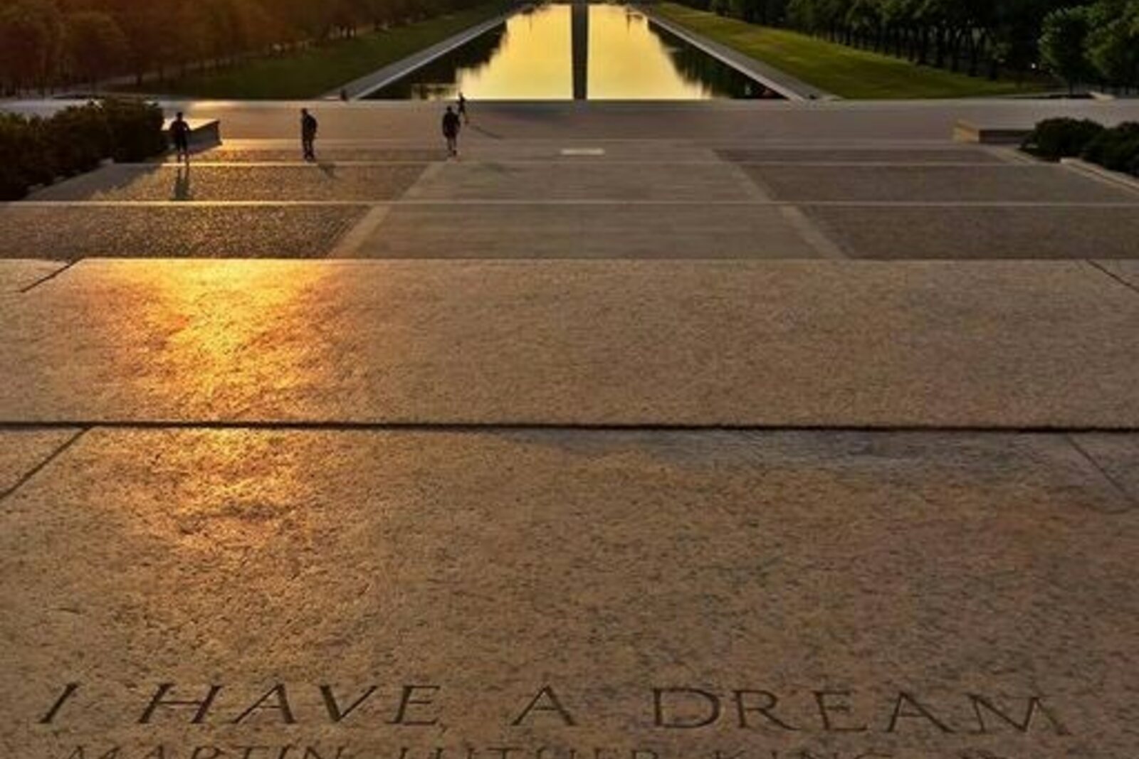 A stone marking a famous speech in front of the Lincoln Memorial and a view of the long pool.
