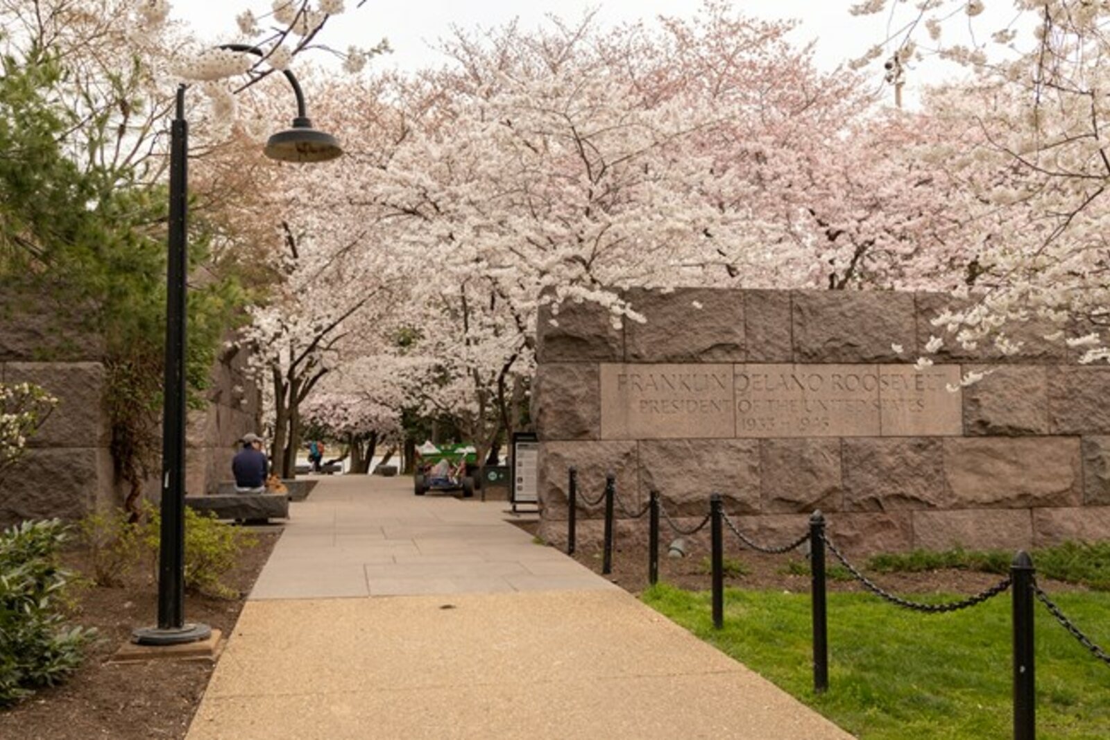 A stone marker of the Franklin Delano Roosevelt Memorial beside a path.