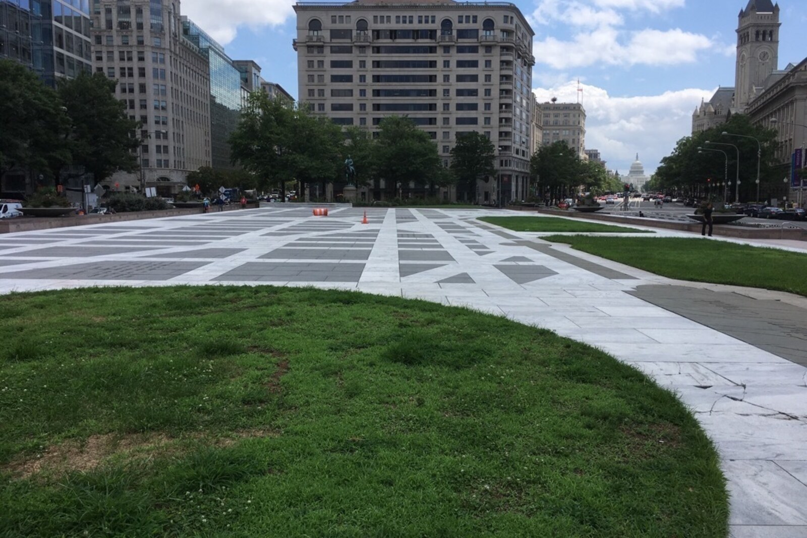 A broad granite-paved plaza with an inset map of Washington and buildings along its edges.