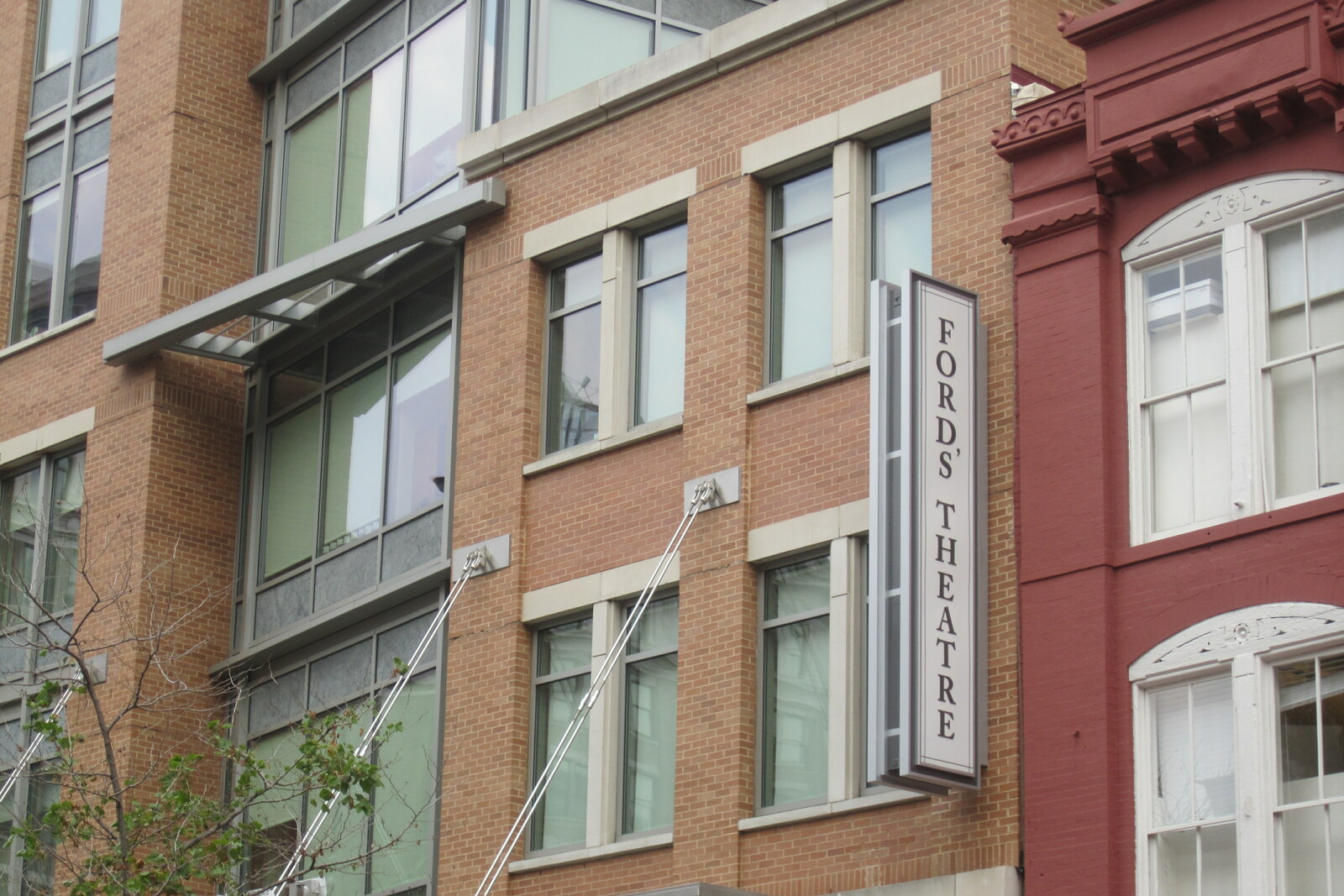 The red-brick facade of Ford's Theatre with white columns and flags.