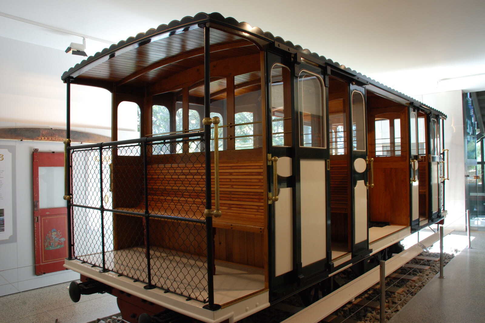 A historic cable car is displayed in the museum against the backdrop of the machinery.