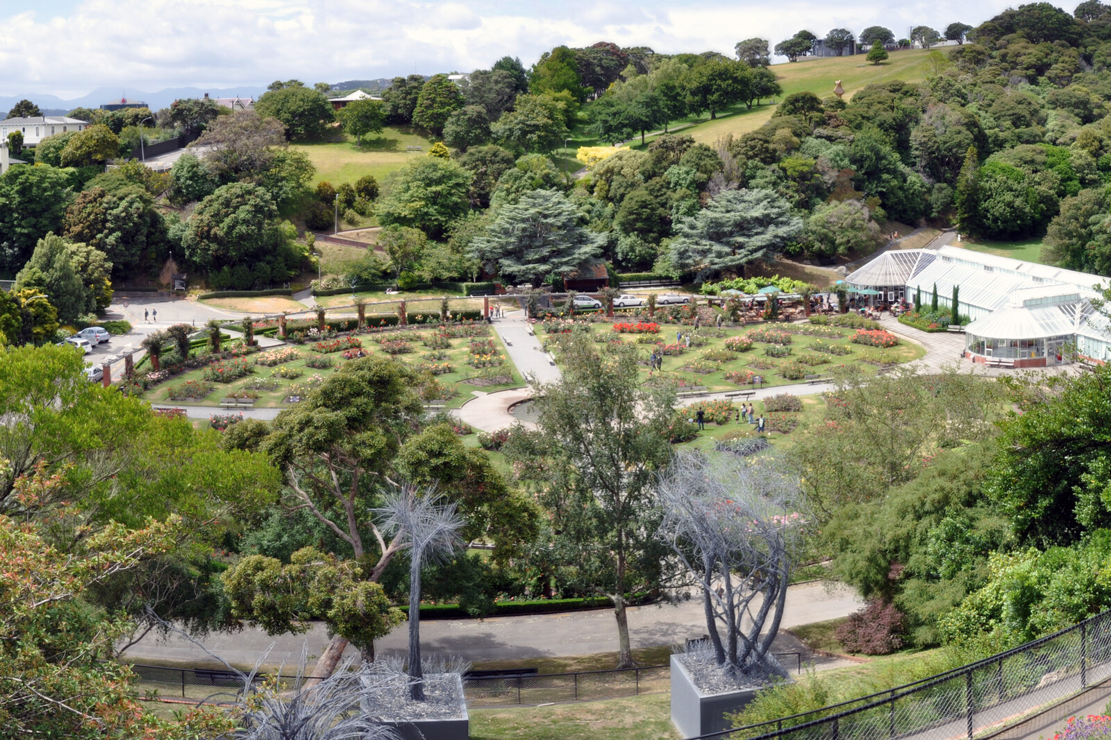 Panorámica del rosal con rosas en flor y una fuente en el centro.