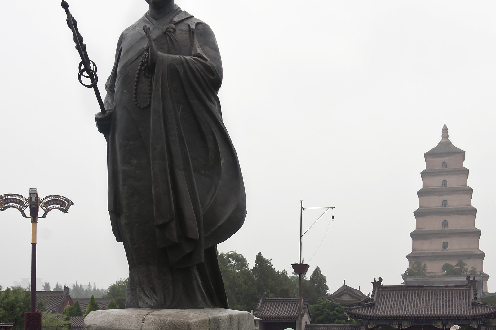 Bronze statue of the monk Xuanzang in the South Square of Giant Wild Goose Pagoda; the pagoda rises behind it.