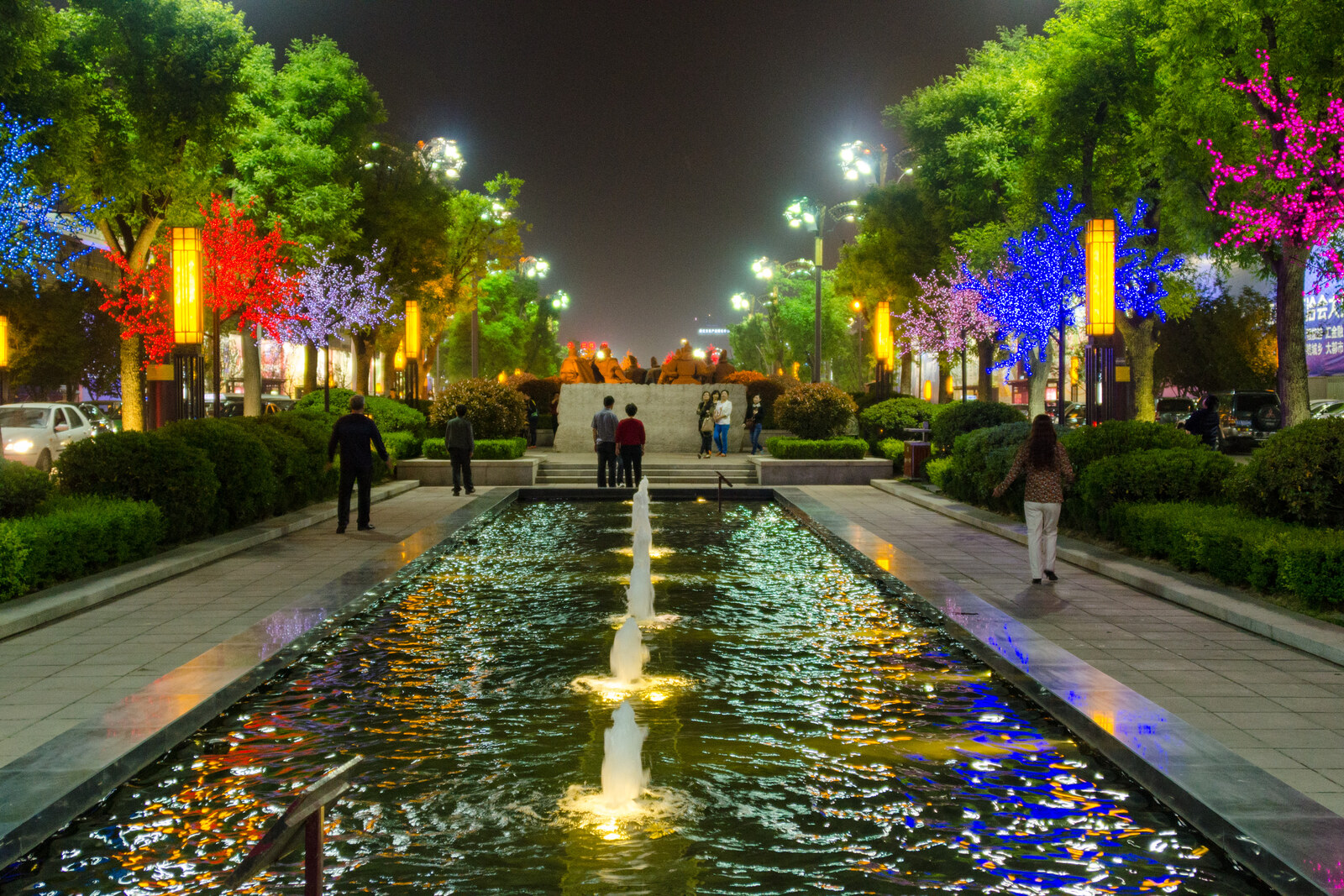 Evening view of Datang Everbright City: a water channel reflects the lights, with decorative buildings and lanterns lining it.