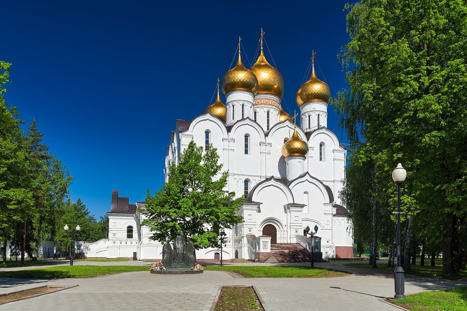 A large white Assumption Cathedral with five gilded domes.