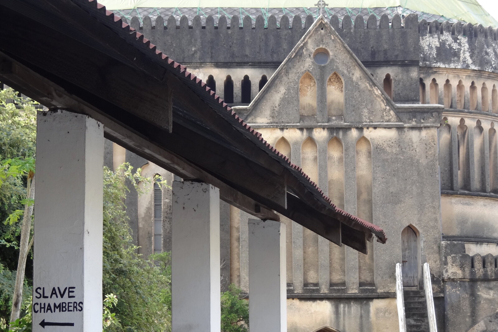 The façade of the Anglican cathedral and a Slave Chambers sign on the grounds of the former slave market beside the memorial; a contextual photograph, not an image of the sculpture itself.