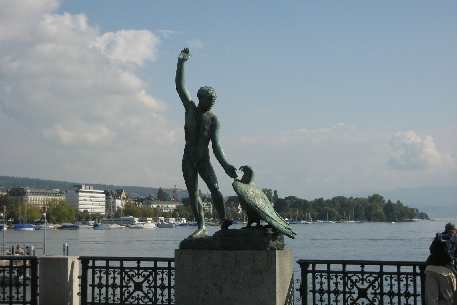 The bronze sculpture “Ganymede” at Bürkliplatz, a youth reaching toward an eagle against the backdrop of the lake.