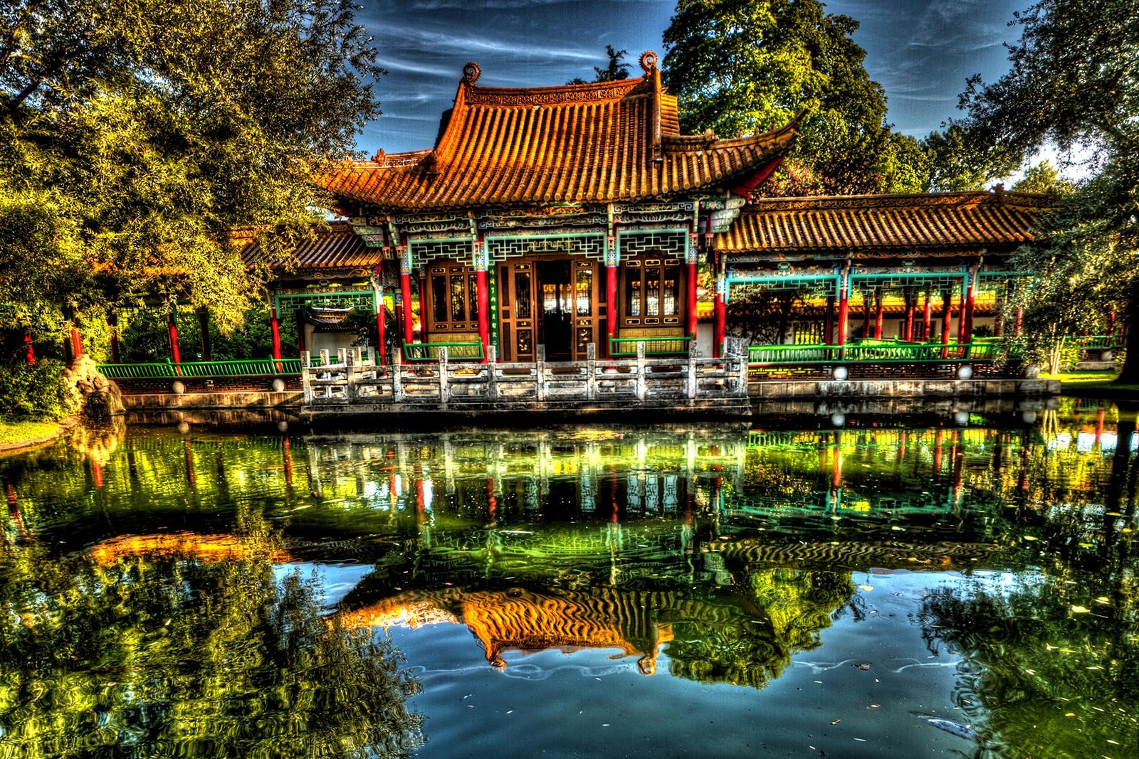The pond and pavilions of the Chinese Garden in Zurich, with reflections and bridges.