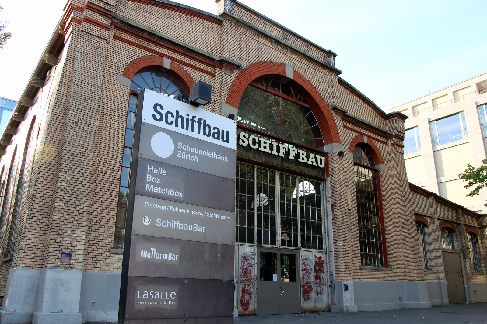 Brick facade of the Schiffbau building with a theater sign