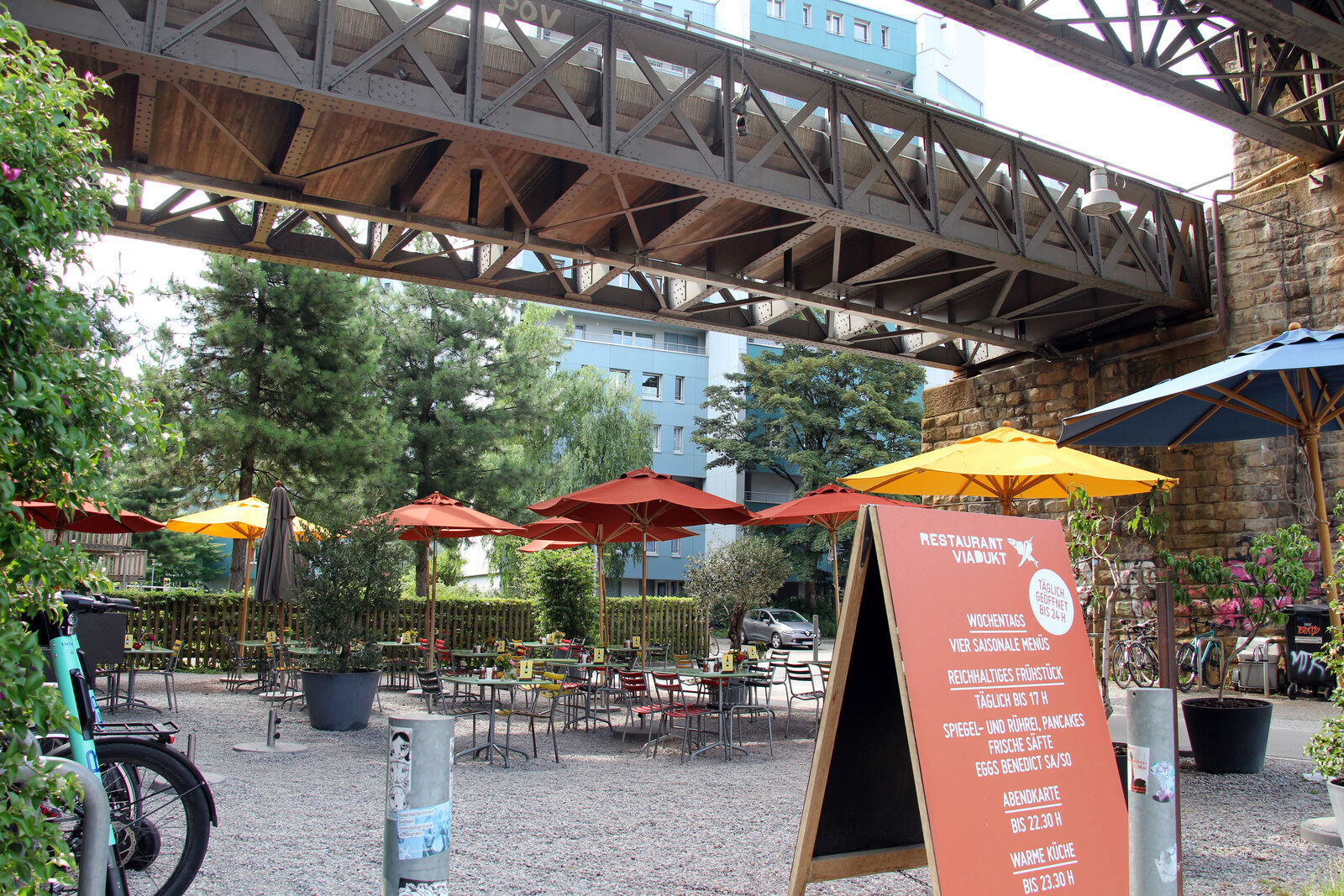 Shopping arches beneath a stone railway viaduct with shop windows
